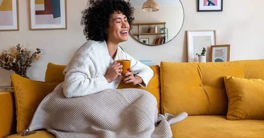 Woman Sitting on the couch drinking coffee