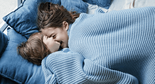 Two children laughing in bed