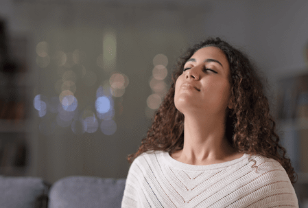 Woman with curly hair smelling the air
