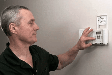 Man adjusting thermostat
