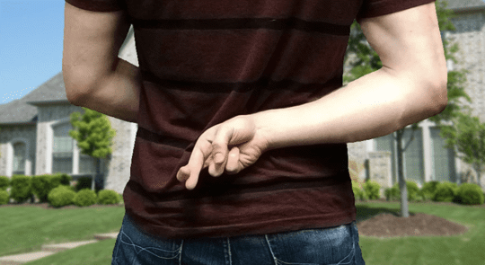 Man with fingers crossed behind his back