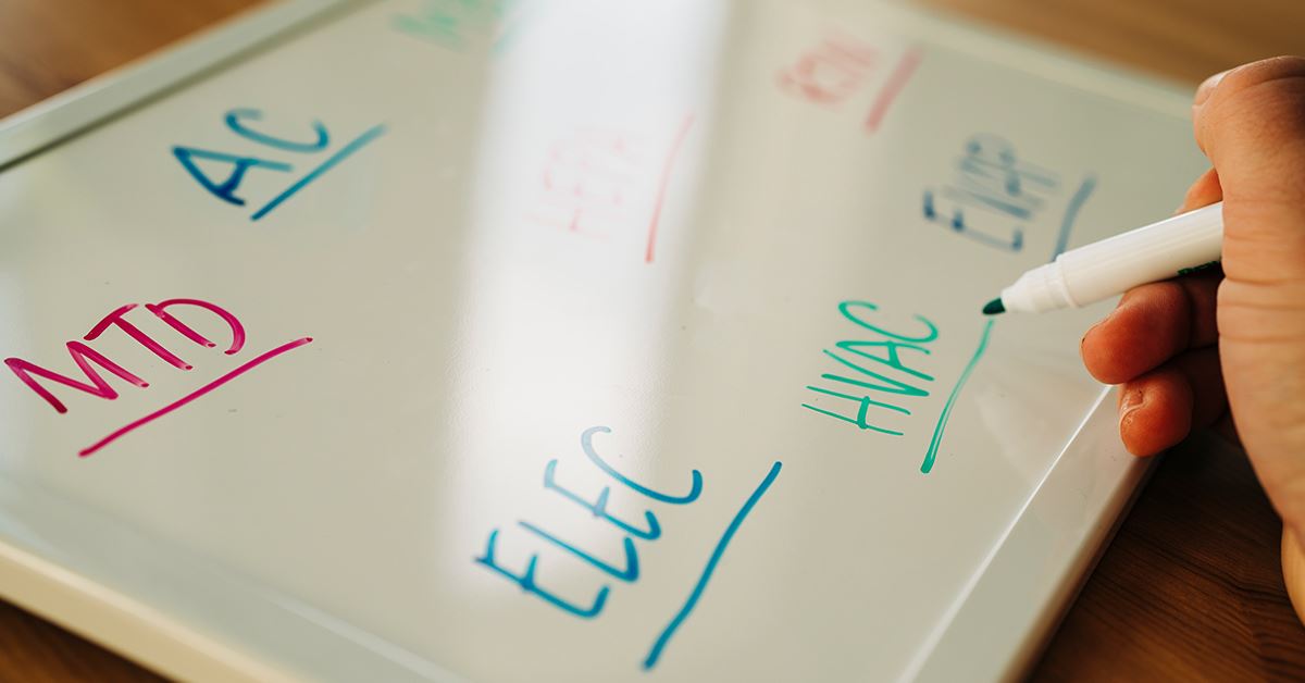HVAC abbreviations written in colorful ink on a whiteboard