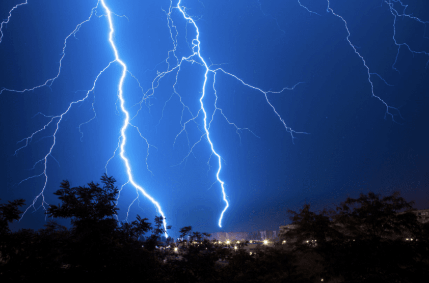Blue lightening strikes in night sky