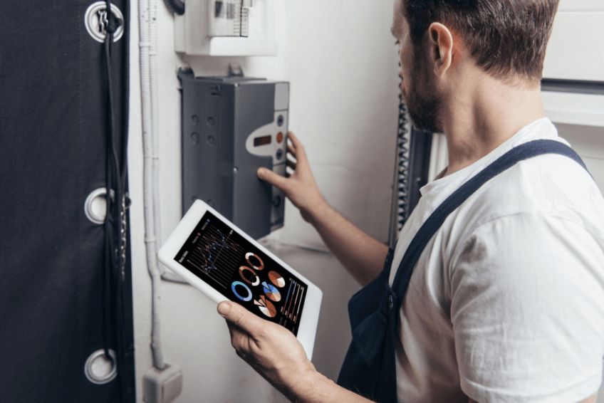 Technician holding iPad fixing surge protector box