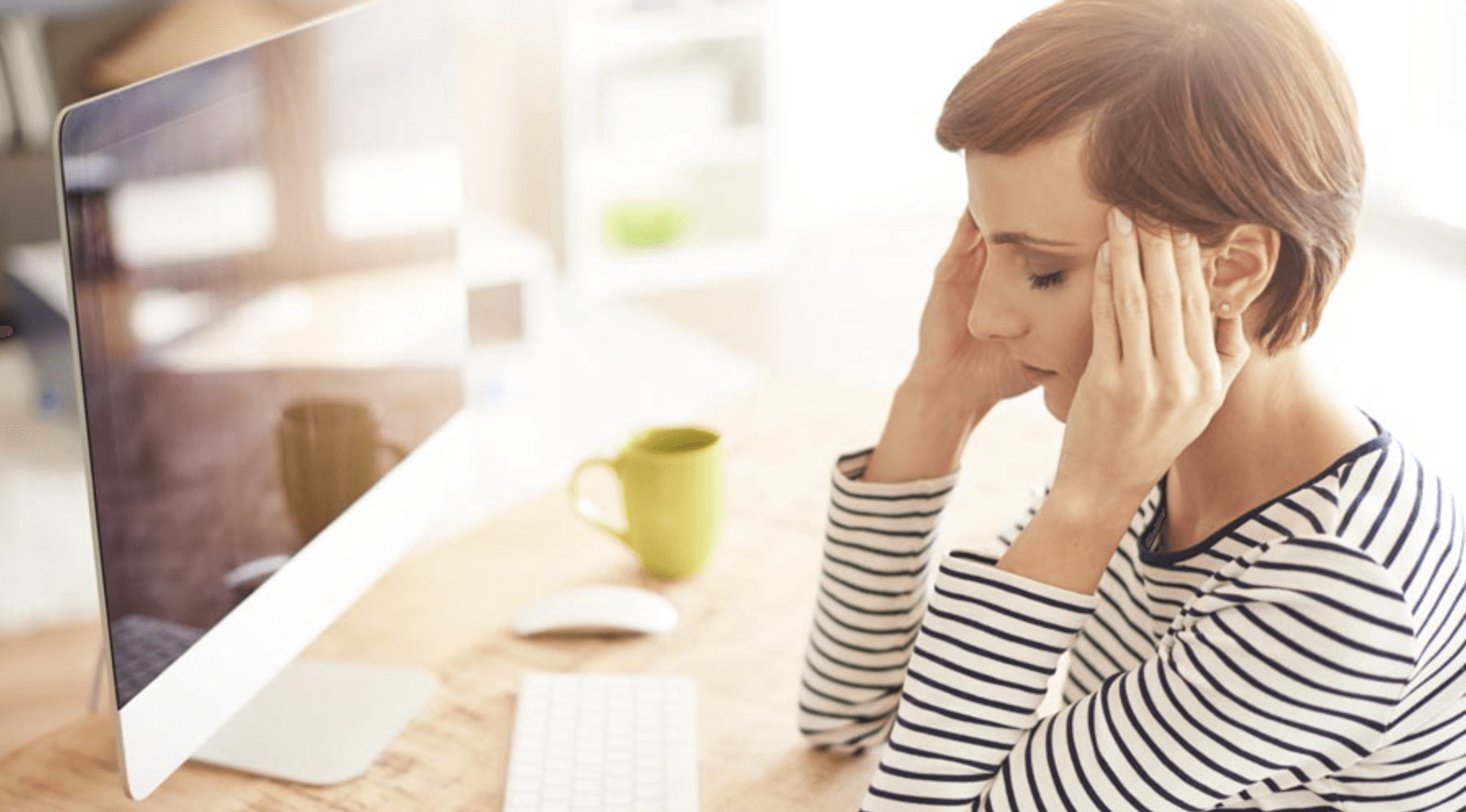 Woman seating at a desk with eyes closed